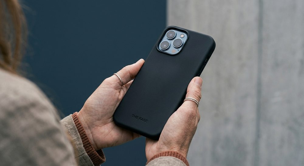 Smartphone dans une coque noire tenu à deux mains